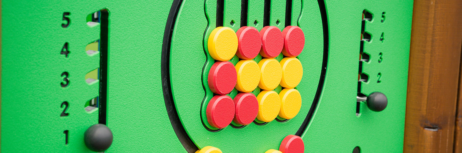 Close up of a play panel at a playground. It's colourful.